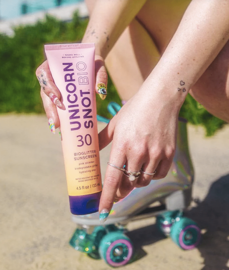 Pink and orange tube of bio glitter sunscreen SPF 30 in print by unicorn snot roller skate colorful wheels